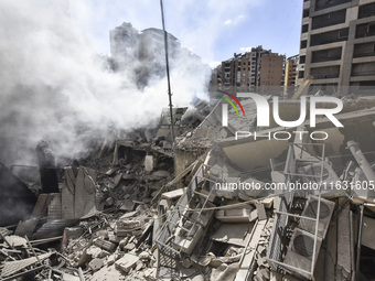 Smoke rises from a building destroyed by an Israeli airstrike as journalists and local residents visit during a press tour in Beirut, Lebano...