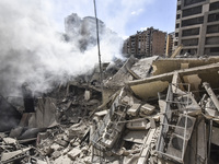 Smoke rises from a building destroyed by an Israeli airstrike as journalists and local residents visit during a press tour in Beirut, Lebano...