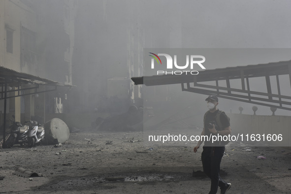 Smoke rises from a building destroyed by an Israeli airstrike as journalists and local residents visit during a press tour in Beirut, Lebano...