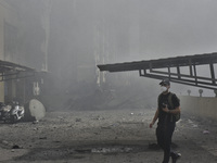 Smoke rises from a building destroyed by an Israeli airstrike as journalists and local residents visit during a press tour in Beirut, Lebano...