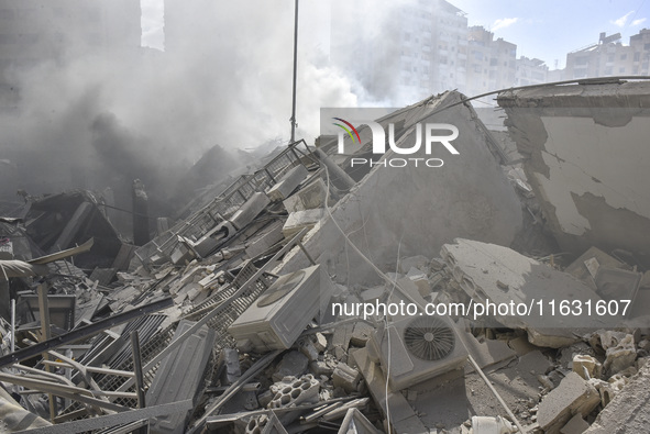 Smoke rises from a building destroyed by an Israeli airstrike as journalists and local residents visit during a press tour in Beirut, Lebano...