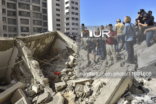 Smoke rises from a building destroyed by an Israeli airstrike as journalists and local residents visit during a press tour in Beirut, Lebano...