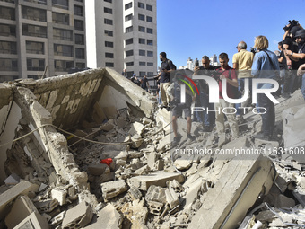 Smoke rises from a building destroyed by an Israeli airstrike as journalists and local residents visit during a press tour in Beirut, Lebano...