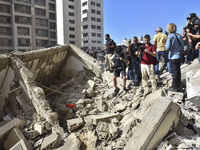 Smoke rises from a building destroyed by an Israeli airstrike as journalists and local residents visit during a press tour in Beirut, Lebano...