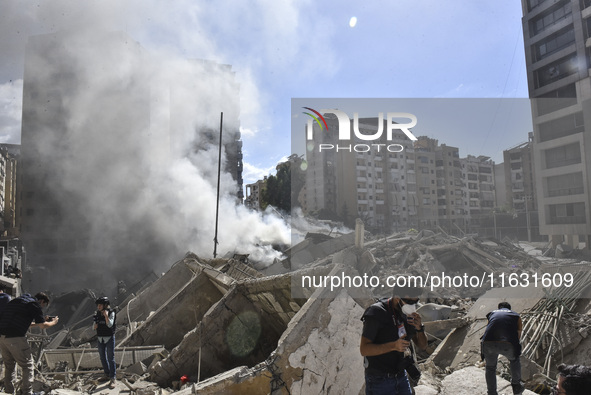 Smoke rises from a building destroyed by an Israeli airstrike as journalists and local residents visit during a press tour in Beirut, Lebano...