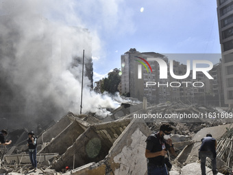 Smoke rises from a building destroyed by an Israeli airstrike as journalists and local residents visit during a press tour in Beirut, Lebano...