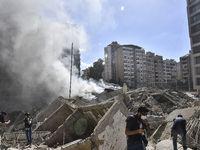 Smoke rises from a building destroyed by an Israeli airstrike as journalists and local residents visit during a press tour in Beirut, Lebano...