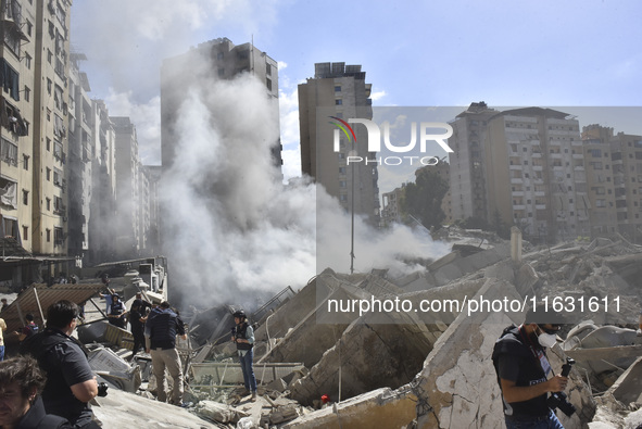 Smoke rises from a building destroyed by an Israeli airstrike as journalists and local residents visit during a press tour in Beirut, Lebano...