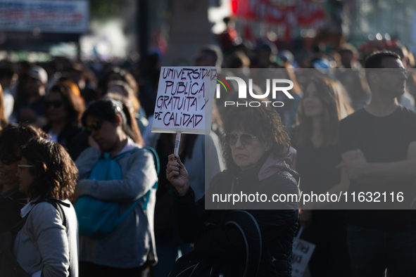 A woman holds a sign that reads ''Free and quality public university'' during a protest against Argentina's President Javier Milei's promise...