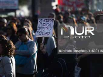 A woman holds a sign that reads ''Free and quality public university'' during a protest against Argentina's President Javier Milei's promise...