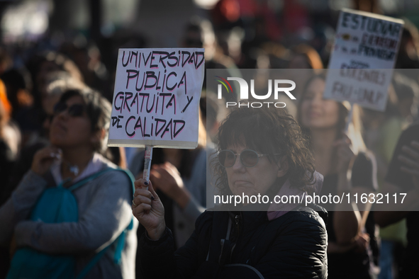 A woman holds a sign that reads ''Free and quality public university'' during a protest against Argentina's President Javier Milei's promise...