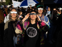 People watch an annular solar eclipse during a protest against Argentina's President Javier Milei's promise to veto a law to finance univers...