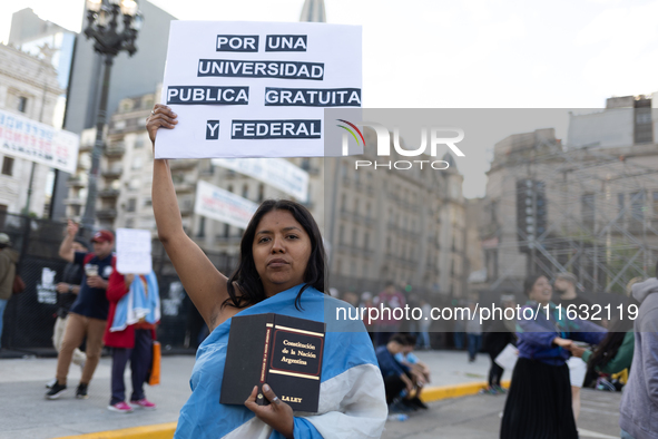 A woman holds a sign that reads ''For a public, free and federal university'' during a protest against Argentina's President Javier Milei's...