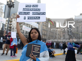 A woman holds a sign that reads ''For a public, free and federal university'' during a protest against Argentina's President Javier Milei's...