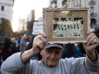 A man holds a photo of his primary class at a public school during a protest against Argentina's President Javier Milei's promise to veto a...