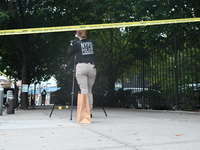 The NYPD Crime Scene Unit canvasses the area outside a senior center where 40-year-old Kavon Reid collapses after he is shot in Bronx, New Y...