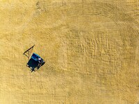 A worker dries rice at a sun-drying farm in Suqian, Jiangsu province, China, on October 2, 2024. (