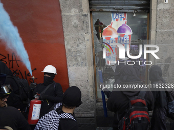 Members of the Bloque Negro Anarquista (Anarchist Black Bloc) take action on establishments in Mexico City, Mexico, on October 2, 2024, duri...