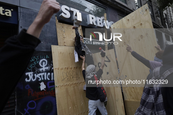 Members of the Bloque Negro Anarquista (Anarchist Black Bloc) take action on establishments in Mexico City, Mexico, on October 2, 2024, duri...