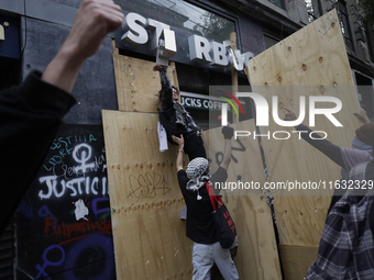 Members of the Bloque Negro Anarquista (Anarchist Black Bloc) take action on establishments in Mexico City, Mexico, on October 2, 2024, duri...