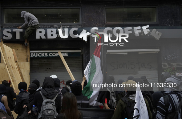 Members of the Bloque Negro Anarquista (Anarchist Black Bloc) take action on establishments in Mexico City, Mexico, on October 2, 2024, duri...