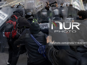 Members of the Anarchist Black Bloc clash with police during the march to mark the 56th anniversary of the Tlatelolco Massacre, which starts...