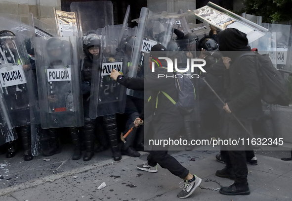 Members of the Anarchist Black Bloc clash with police during the march to mark the 56th anniversary of the Tlatelolco Massacre, which starts...