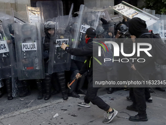 Members of the Anarchist Black Bloc clash with police during the march to mark the 56th anniversary of the Tlatelolco Massacre, which starts...