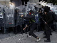 Members of the Anarchist Black Bloc clash with police during the march to mark the 56th anniversary of the Tlatelolco Massacre, which starts...