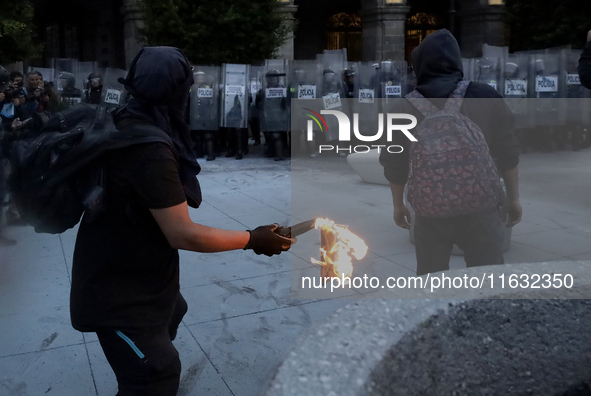 Members of the Anarchist Black Bloc throw Molotov cocktails at the police during the march to mark the 56th anniversary of the Tlatelolco Ma...