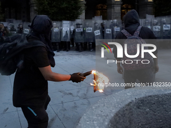 Members of the Anarchist Black Bloc throw Molotov cocktails at the police during the march to mark the 56th anniversary of the Tlatelolco Ma...