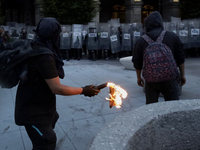 Members of the Anarchist Black Bloc throw Molotov cocktails at the police during the march to mark the 56th anniversary of the Tlatelolco Ma...