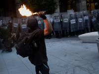 Members of the Anarchist Black Bloc throw Molotov cocktails at the police during the march to mark the 56th anniversary of the Tlatelolco Ma...