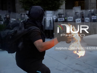 Members of the Anarchist Black Bloc throw Molotov cocktails at the police during the march to mark the 56th anniversary of the Tlatelolco Ma...