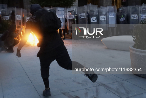 Members of the Anarchist Black Bloc throw Molotov cocktails at the police during the march to mark the 56th anniversary of the Tlatelolco Ma...