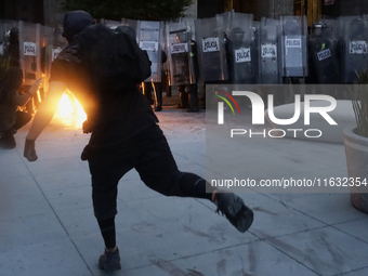 Members of the Anarchist Black Bloc throw Molotov cocktails at the police during the march to mark the 56th anniversary of the Tlatelolco Ma...