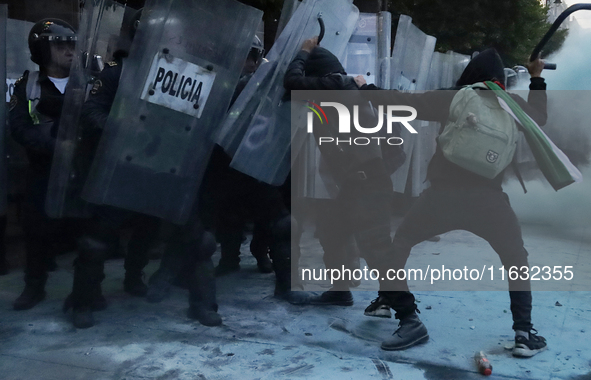 Members of the Anarchist Black Bloc clash with police during the march to mark the 56th anniversary of the Tlatelolco Massacre, which starts...