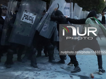 Members of the Anarchist Black Bloc clash with police during the march to mark the 56th anniversary of the Tlatelolco Massacre, which starts...