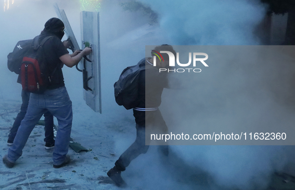 Members of the Anarchist Black Bloc clash with police during the march to mark the 56th anniversary of the Tlatelolco Massacre, which starts...