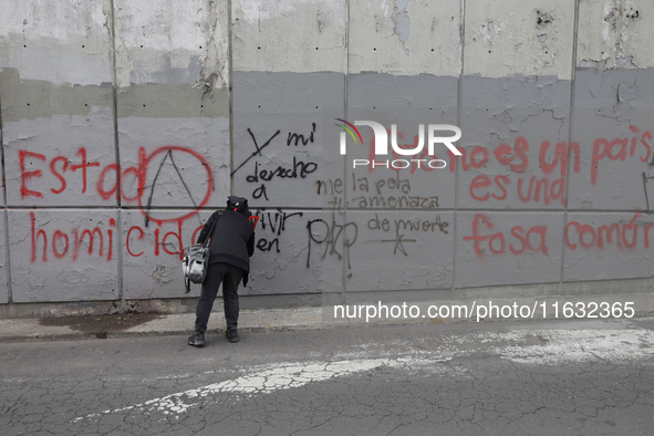 Members of the Anarchist Black Bloc paint graffiti during the march to mark the 56th anniversary of the Tlatelolco Massacre that occurred on...