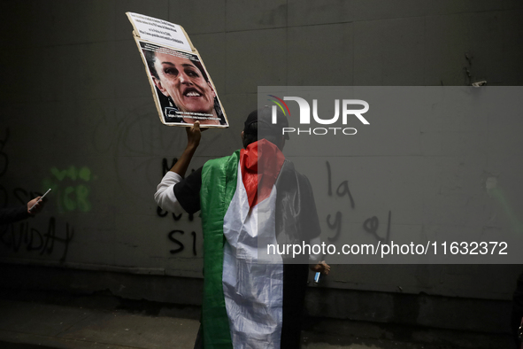 Members of the Anarchist Black Bloc paint graffiti during the march to mark the 56th anniversary of the Tlatelolco Massacre that occurred on...