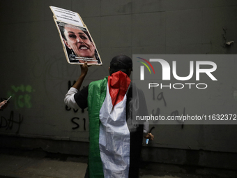 Members of the Anarchist Black Bloc paint graffiti during the march to mark the 56th anniversary of the Tlatelolco Massacre that occurred on...