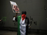 Members of the Anarchist Black Bloc paint graffiti during the march to mark the 56th anniversary of the Tlatelolco Massacre that occurred on...