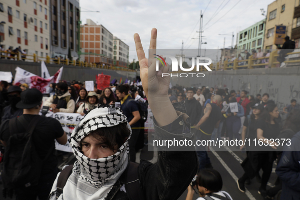 Members of the Anarchist Black Bloc paint graffiti during the march to mark the 56th anniversary of the Tlatelolco Massacre that occurred on...