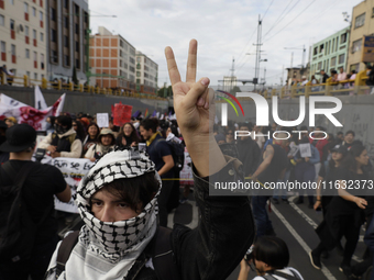 Members of the Anarchist Black Bloc paint graffiti during the march to mark the 56th anniversary of the Tlatelolco Massacre that occurred on...