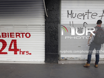 Members of the Anarchist Black Bloc paint graffiti during the march to mark the 56th anniversary of the Tlatelolco Massacre that occurred on...