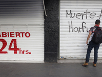 Members of the Anarchist Black Bloc paint graffiti during the march to mark the 56th anniversary of the Tlatelolco Massacre that occurred on...