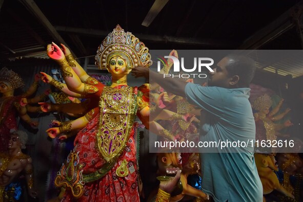 An artisan decorates the idol of the Hindu Goddess Durga ahead of the Durga Puja festival in Nagaon District, Assam, India, on October 3, 20...