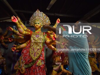 An artisan decorates the idol of the Hindu Goddess Durga ahead of the Durga Puja festival in Nagaon District, Assam, India, on October 3, 20...