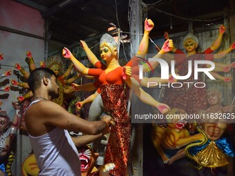 An artisan decorates the idol of the Hindu Goddess Durga ahead of the Durga Puja festival in Nagaon District, Assam, India, on October 3, 20...